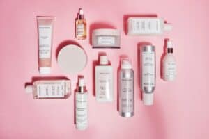 Produkty do pielęgnacji włosów na różowym tle.