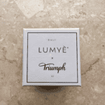 Pudełko Lumyè x Triumph na marmurowym tle.