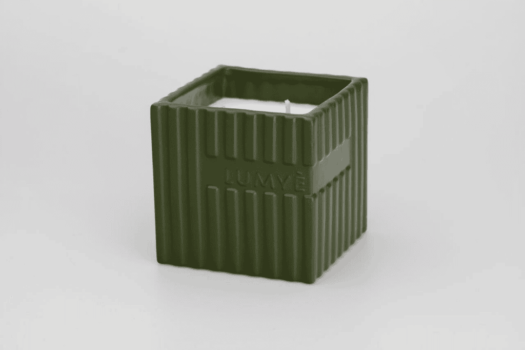 Zielona świeca w kwadratowej ceramicznej podstawce