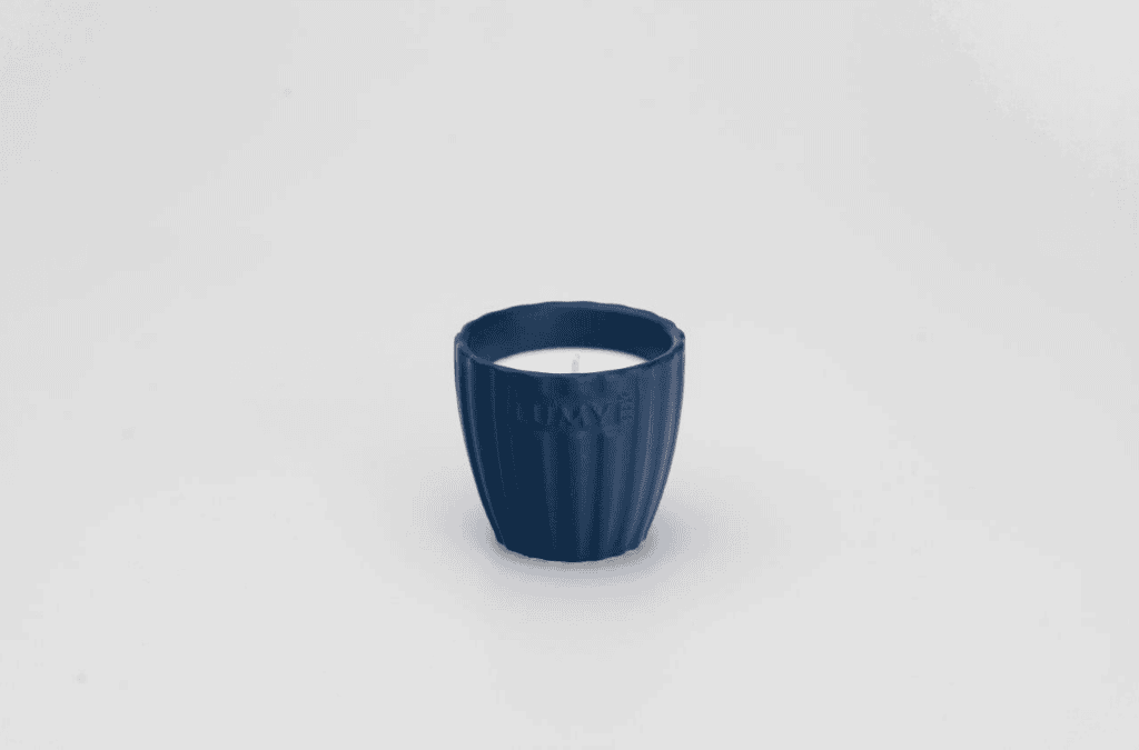 Granatowa świeca w ceramicznej osłonce.